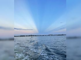 A stunning sunset view over the coastline, showcasing beautiful rays of light and tranquil waters — perfect for capturing the essence of a relaxing boat trip.