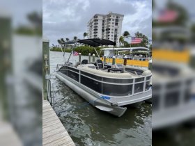 A sleek pontoon boat docked at a marina, showcasing its spacious design and comfortable seating, perfect for leisurely outings on the water.