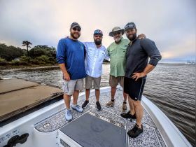 A group of friends poses together on the deck of a boat, capturing a memorable moment on the water — perfect for celebrating adventures with friends.