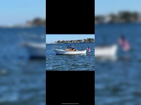 A classic speedboat cruising through calm waters, showcasing its sleek design and American flag — perfect for a day on the water.