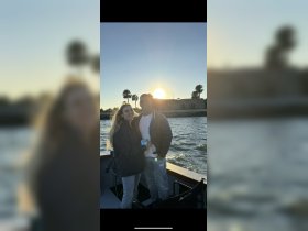 A couple enjoys a romantic moment on a boat at sunset, capturing the essence of love and adventure on the water.