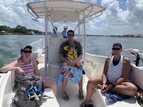 A joyful family enjoys a day on the water, with smiles and laughter aboard their boat — perfect for creating lasting memories together.