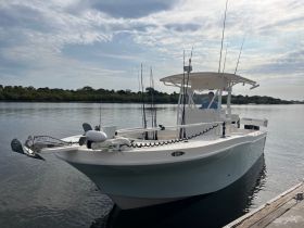 A well-equipped center console fishing boat docked by the water, ready for a day of fishing adventures.