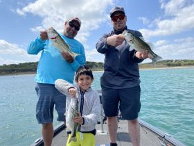 A joyful family fishing trip on the water, showcasing a successful catch of bass — perfect for creating lasting memories together.