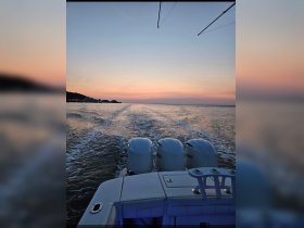 A serene view of a boat cruising at sunset, showcasing the tranquil waters and the fading light — perfect for evening excursions.