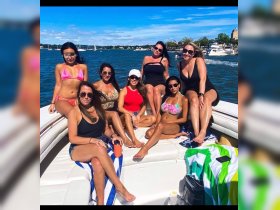 A vibrant group of friends enjoys a sunny day on a boat, showcasing the perfect summer celebration on the water.