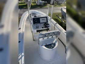 A detailed view of the helm and console area of a boat, showcasing the SIMRAD display and seating arrangements, perfect for navigating the waters.