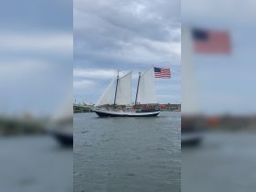 A majestic sailing ship with a group of passengers enjoying the ride on the water, showcasing the beauty of sailing experiences.