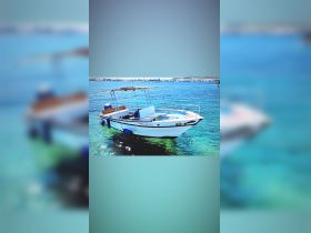 A beautiful boat anchored in clear turquoise waters, showcasing its sleek design and inviting atmosphere for a perfect day on the water.