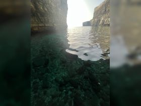 A stunning view of a serene waterway framed by rocky cliffs, showcasing the natural beauty of the coastline — perfect for eco tours and scenic boat trips.