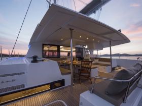 A beautifully designed interior of a yacht featuring a spacious dining area and comfortable seating, perfect for relaxing and enjoying meals while cruising.