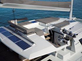A spacious interior view of a modern catamaran featuring comfortable seating and a well-equipped helm, perfect for leisurely sailing adventures.