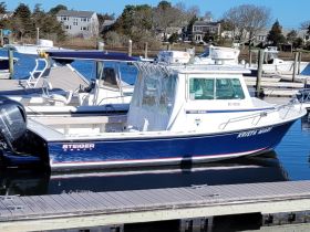 A clear view of the 'Krista Mari', a Steiger Craft boat docked at the marina, showcasing its sleek design and structure.
