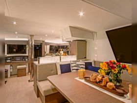 A beautifully designed interior of a yacht featuring a cozy dining area, modern amenities, and elegant decor, perfect for relaxing and entertaining on the water.