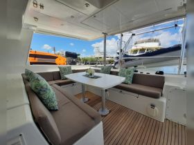 A beautifully designed interior of a boat featuring a cozy dining area with plush seating and a view of the marina, perfect for relaxing and enjoying meals on the water.