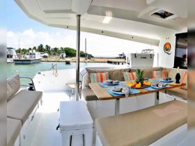 A beautifully arranged dining area inside a boat, featuring comfortable seating and a table set for a delightful meal, perfect for enjoying meals on the water.