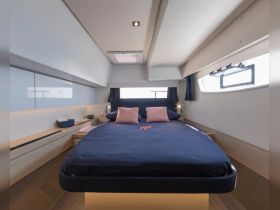 A modern and spacious cabin interior featuring a comfortable bed and stylish decor, perfect for relaxing on a yacht.