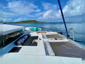 A cozy lounge area on a catamaran, featuring comfortable seating and a stunning view of the water, perfect for relaxing during a sailing adventure.