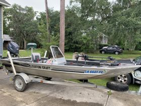 A custom craft boat parked and ready for adventure, showcasing its sleek design and features in a residential setting.