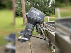 Close-up of a Yamaha outboard motor mounted on a boat, showcasing the engine details and surrounding environment.