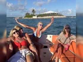 A joyful group of friends enjoys a sunny day on the water, celebrating together aboard a boat — perfect for memorable outings and fun adventures.