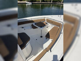 A well-appointed interior view of a boat's seating area, featuring comfortable cushions and a table, perfect for relaxing while on the water.