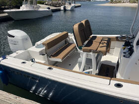 The interior of a well-equipped boat featuring comfortable seating and a helm area, perfect for fishing or leisure outings.