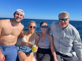 A cheerful group of friends enjoys a sunny day on the water, capturing the essence of fun and relaxation while boating together.