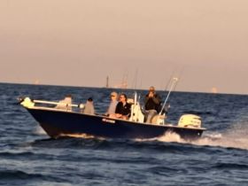 A group of friends enjoys a fishing trip on a boat, navigating through the ocean waves — perfect for adventure seekers and fishing enthusiasts.