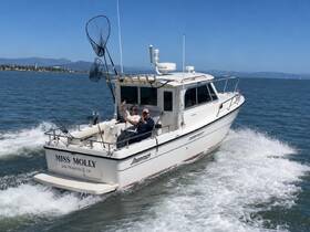 Two anglers aboard the 'Miss Molly' enjoy a sunny day on the water, showcasing the excitement of fishing adventures in San Francisco Bay.