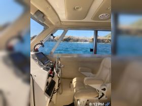 A well-equipped helm area inside a boat, featuring a comfortable captain's chair and control console, perfect for navigating the open waters.