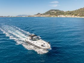 A sleek speedboat glides through the clear blue waters, showcasing its elegant design and perfect for thrilling adventures on the sea.