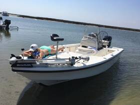 A woman relaxes on the deck of a boat, enjoying the sun and water — a perfect scene for a leisurely day on the water.