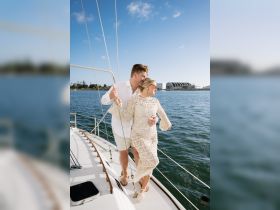 A couple enjoys a romantic moment on the deck of a yacht, perfect for celebrating special occasions or intimate getaways on the water.
