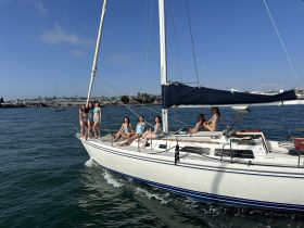 A lively group of friends enjoys a day sailing on a yacht, showcasing fun and camaraderie on the water.