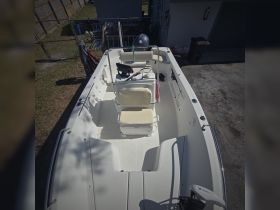 An interior view of a well-equipped boat helm featuring comfortable seating and a console, ideal for a day out on the water.