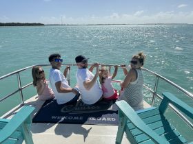 A joyful family enjoys their time aboard a boat, taking in the beautiful ocean views — a perfect moment for creating lasting memories on the water.