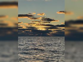 A stunning sunset over the ocean, with rays of light breaking through the clouds — a perfect backdrop for evening boat trips and serene moments on the water.