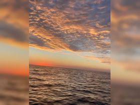A breathtaking sunset over the ocean, showcasing vibrant colors and serene waters — perfect for capturing the beauty of nature during a boating adventure.