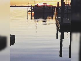 A serene sunset view of a boat docked at the marina, reflecting beautifully on the calm waters — perfect for capturing the tranquility of evening boat life.
