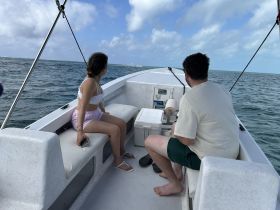 A couple enjoys a scenic boat ride, taking in the beautiful ocean views while exploring the waters. Perfect for adventure seekers and romantic outings.
