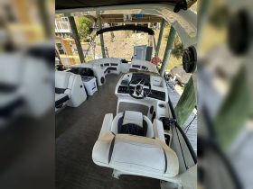 Interior view of a well-equipped boat helm featuring comfortable seating and modern controls, perfect for navigating the waters.