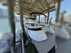 A sleek Bennington boat docked under a covered area, showcasing its stylish design and spacious seating — perfect for leisurely outings on the water.