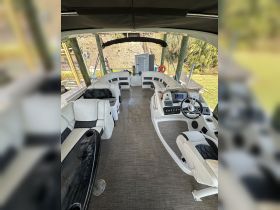 Interior view of a spacious boat cabin featuring comfortable seating and a well-equipped helm, perfect for relaxing and navigating on the water.