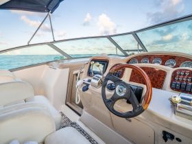A well-appointed helm area of a boat, showcasing the steering console and comfortable seating, perfect for navigating the open waters.