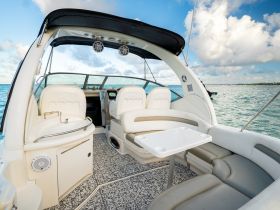 A spacious interior view of a boat's helm and seating area, showcasing comfortable amenities for a relaxing day on the water.