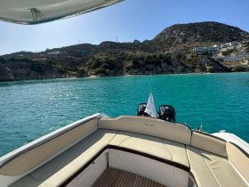 A serene view from the deck of a boat, showcasing the stunning turquoise waters and rocky coastline, perfect for a day of exploration on the water.