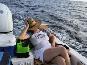 A woman relaxes on a boat, enjoying the ocean breeze and sunshine — a perfect moment for unwinding on the water.