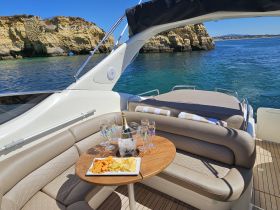 A beautifully arranged table with snacks and drinks on a luxurious boat, perfect for enjoying a relaxing day on the water.