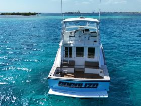 A stunning aerial view of the 'Cocolizo' boat cruising through crystal-clear turquoise waters, perfect for exploring beautiful coastal destinations.